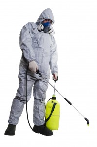 A pest control worker wearing a mask, hood, protective suit and dual air filters holding a hose to help exterminate rats and other vermin.