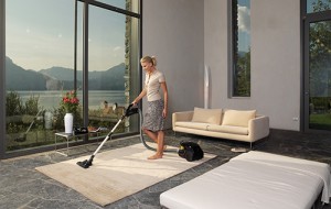 housewife with vacuum cleaner in a room