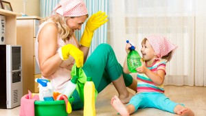 happy mother with kid cleaning room and having fun